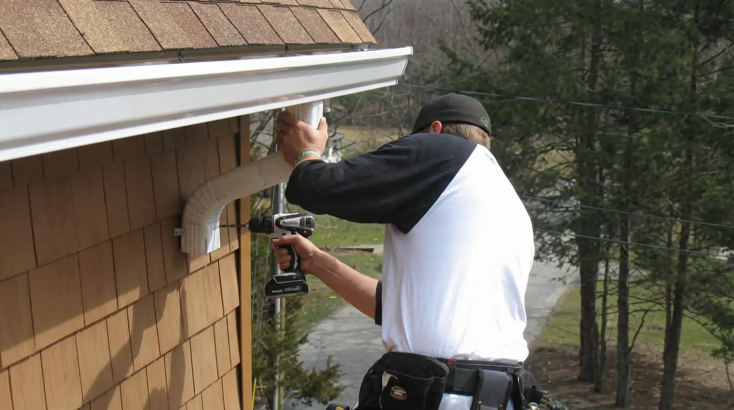 Professional contractor installing tan vinyl siding panels on a residential home exterior in Fort Lauderdale, FL